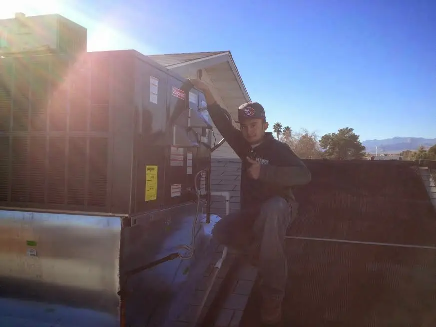 HVAC technician performing AC Tune-Up on a rooftop unit in Salt Lake City